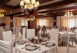 坎巴多斯圣马科斯撒尼斯酒店的一间配备有白色桌椅和吊灯的餐厅