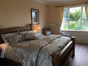 卡林福德格卢屋住宿加早餐酒店的一间卧室设有一张大床和一个窗户。