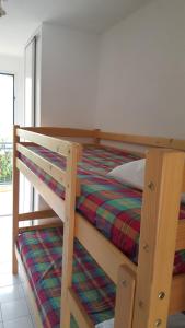 勒拉旺杜Résidence AZUR1 Appartement 251的一间卧室配有带条纹毯子的双层床
