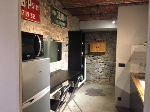 DaillyDailly studio的厨房配有台面,墙上配有电视