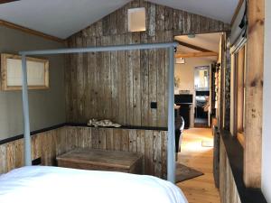 LlandeglaFaraway Follies的一间卧室设有木墙和床