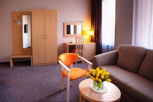 克拉斯诺达尔克拉斯诺达尔酒店的客厅配有沙发和花瓶(桌子上)