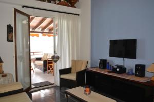 希维利Acrogiali Sunshine的带电视的客厅和带沙发的客厅。