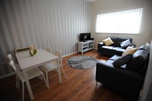利物浦利物浦两卧室公寓 的客厅配有桌子和沙发