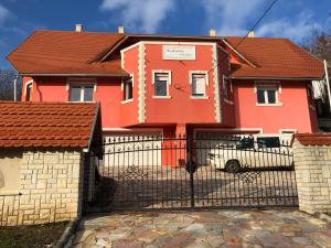 米什科尔茨道波曹Kedvenc Vendégház的橙色的房子,设有门和栅栏