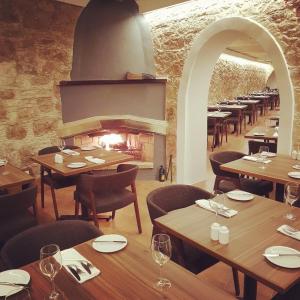 皮斯索里葡萄园宾馆的餐厅设有木桌、椅子和壁炉