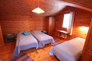Hyytiälä玛科兰洛玛图瓦特住宿加早餐酒店的小木屋内一间卧室,配有两张床