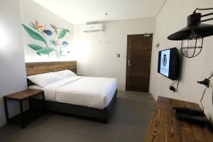 马尼拉马卡蒂U酒店的一间卧室配有一张床和一台电视。