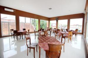 日惹RedDoorz Plus @ Timoho的用餐室设有桌椅和窗户。