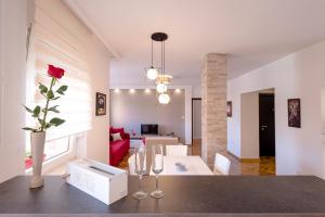 诺维萨德Apartman Arte的客厅,配有带玫瑰花瓶的桌子