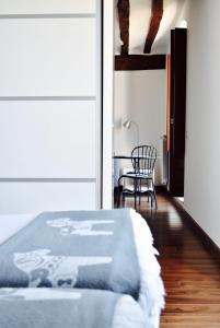 仕格莱Apartamentos Turísticos Rincones del Vino的卧室配有1张床、1张桌子和1把椅子