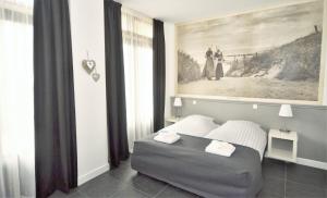 栋堡DAC50 Luxurious apartment Domburg的卧室配有一张床,墙上挂有绘画作品