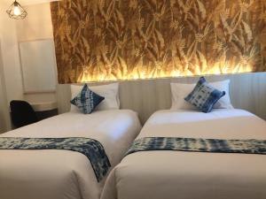 乌隆他尼UD首府酒店的配有2张单人床的带墙壁客房