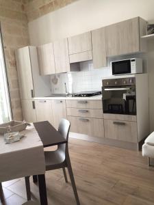 滨海波利尼亚诺Stella di Mare Dimora Charme的厨房配有白色橱柜、桌子和用餐室。