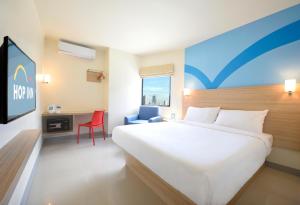 马尼拉Hop Inn Hotel Aseana City Manila的酒店客房设有一张大床和一张书桌。