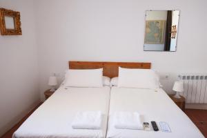 塔拉戈纳皮加尔酒店的配有白色床单的客房内的两张床