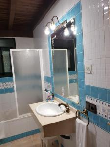 安特克拉Casa Rural El Conde的浴室配有盥洗盆、镜子和浴缸