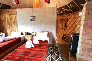 AlamedinSupara Chunkurchak的一间设有两张床铺的卧室,位于一个设有墙壁的房间