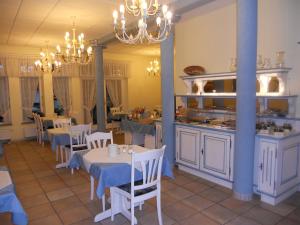 辛斯海姆赫希跨国酒店的一间带白色桌椅的餐厅和一间厨房