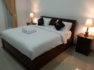 珀尼达岛Ega Homestay的卧室配有一张带白色床单和枕头的大床。