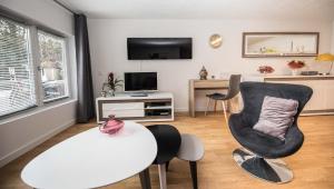 日内瓦红衣主教之点公寓的客厅配有椅子和桌子