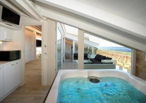 雷卡纳蒂港Opera Arte Suite Apartments的景观客房内的大浴缸