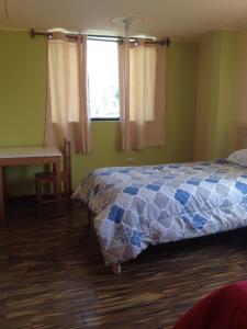 YanqueLos Geranios的一间卧室配有一张床、一张书桌和一个窗户。