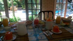 尼泰罗伊Belo recanto的一张桌子,早餐包括牛奶和橙汁