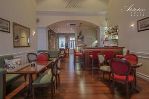 埃尔莫波利斯Hotel Aktaion Syros的一间带桌椅的餐厅和一间酒吧