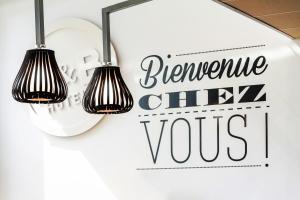 贝尔福B&B HOTEL Belfort Bessoncourt的挂在墙上的两盏灯,上面有写着令人讨厌的厨师的标语