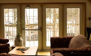 布莱顿木制度假山林小屋的客厅设有滑动玻璃门和桌子