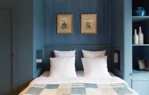 蒙尼肯丹品质住宿酒店的一间卧室拥有蓝色的墙壁,配有一张带白色枕头的床。
