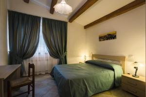 拉波拉诺泰尔梅San Paterno B&B的一间卧室配有一张床、一张书桌和一个窗户。