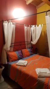 Lugagnano Val dʼArdaLa Locanda dei Cavalieri Affittacamere的一间卧室配有白色窗帘的床