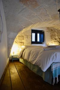 奥斯图尼La Violetta Ostuni的卧室配有一张石墙床