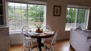 Myrtle CreekCharming, Private Cottage in Myrtle Creek的一间带桌椅和窗户的用餐室