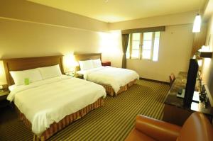 台东康桥商旅-台东馆的酒店客房设有两张床和电视。