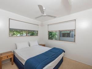 伍德盖特NRMA Woodgate Beach Holiday Park的一间卧室设有一张床和两个窗户。