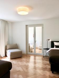 苏黎世VIADUKT公寓式酒店的带沙发、椅子和滑动玻璃门的客厅