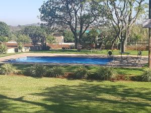 RietfonteinMarjaniek Wedding Venue & Guest House的公园里的一个游泳池,有树木和草地