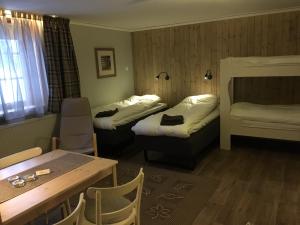赛纳Knappgården的酒店客房设有两张床和一张桌子。