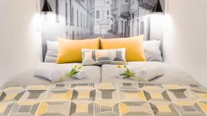 杰尔Luxury Studio 24的一张黄色和白色枕头的床,床上有鲜花