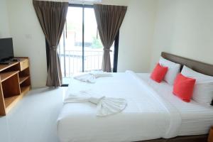 奈扬海滩DOS'S HOUSE的卧室配有带红色枕头的大型白色床