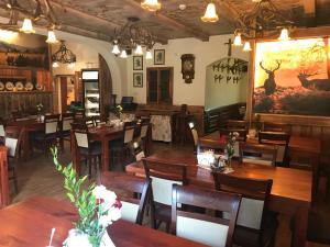 KaczorówPodgórzanka的餐厅设有木桌和椅子,墙上挂有绘画作品