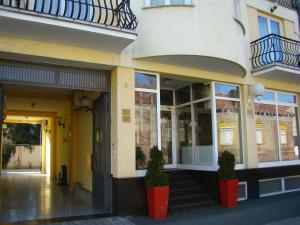 奥西耶克Hotel Vila Ariston的前面有两株盆栽植物的建筑