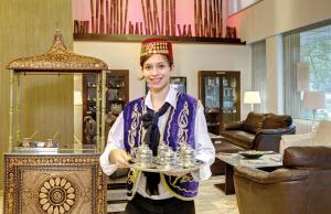 伊兹密尔苏苏鲁亚特兰蒂斯酒店的一个女人拿着一个装有水瓶的托盘