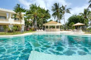 马林迪Sandies Malindi Dream Garden的棕榈树建筑前的游泳池