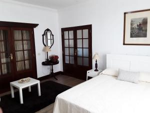 塔科龙特La Chimenea Verde的卧室配有白色的床和桌子