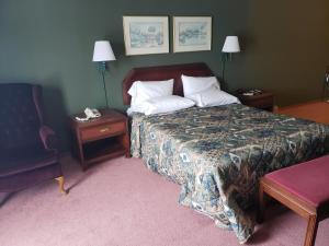 KewauneeHarbor Lights Lodge的配有一张床和一把椅子的酒店客房