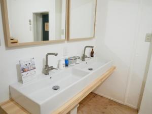 神户居家公园旅馆的浴室设有白色水槽和镜子